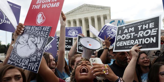 Anti-abortion demonstrators celebrate outside the United States Supreme Court as the court rules in the Dobbs v Women’s Health Organization abortion case, overturning the landmark Roe v Wade abortion decision in Washington, giugno 24, 2022.