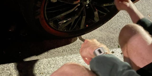 Activists with the group Tyre Extinguishers slash tires of an SUV parked in New York City on Tuesday.