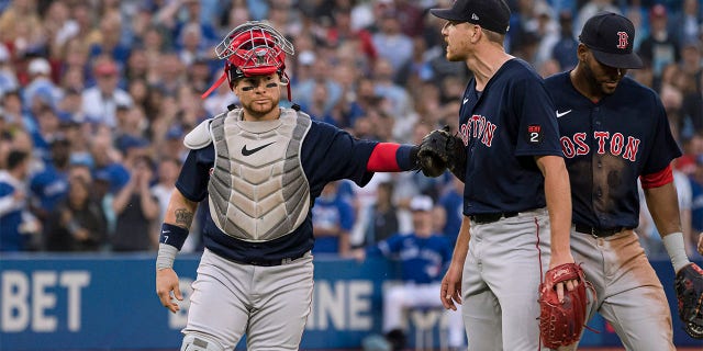 Boston Red Sox catcher Christian Vazquez holds back starting pitcher Nick Pivetta (37) during a heated exchange with the Toronto Blue Jays after Blue Jays' Alejandro Kirk was hit by a pitch during the fourth inning of a baseball game Wednesday, June 29, 2022, in Toronto.