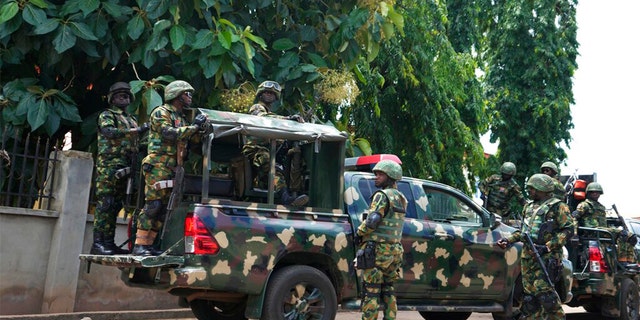 FILE: Nigerian soldiers secure the area outside of the St. Francis Catholic Church in the town of Owo, Nigeria, Monday, June 6, 2022, a day after an attack that targeted worshipers.