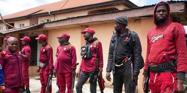 Vigilantes stand guard outside the St. Louis Catholic Hospital in the city of Owo, Nigeria, Monday, June 6, 2022.