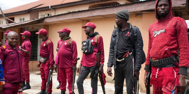 Vigilante stand guard outside of the St Louis Catholic hospital in the town of Owo, Nigeria, Monday, June 6, 2022