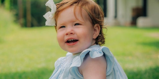 The Duke and Duchess of Sussex shared the first photo of daughter Lilibet smiling in a blue dress with a white bow in her bright red hair