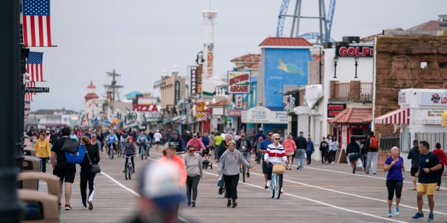 Crowds of people ride bikes and walk along the boardwalk after COVID-19 restrictions were lifted in time for the Memorial Day weekend in Ocean City, N.J., May 25, 2020.
