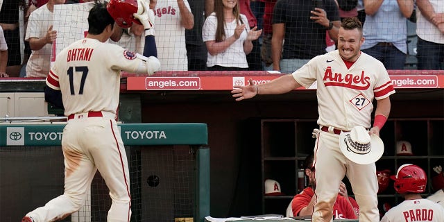 Los Angeles Angels' Mike Trout, right, extends his hand to Shohei Ohtani to celebrate Ohtani's home run during the third inning of the team's baseball game against the Chicago White Sox on Tuesday, June 28, 2022, in Anaheim, Calif.
