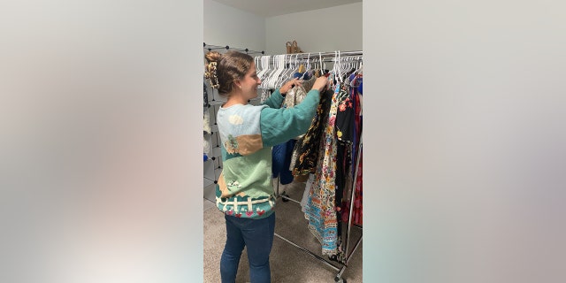 Olivia Ray sorts through some of the clothing she's selling on Poshmark. Her plan is to have her student loan paid off entirely by 2026. 