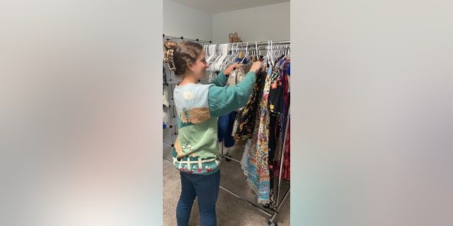 Olivia Ray sorts through some of the clothing she's selling on Poshmark. Her plan is to have her student loan paid off entirely by 2026.