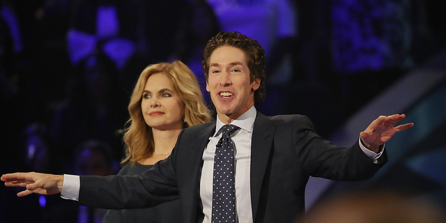 Joel Osteen, the pastor of Lakewood Church, stands with his wife, Victoria Osteen, as he conducts a service.