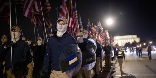 Members of the right-wing group Patriot Front march across Memorial Bridge in front of the Lincoln Memorial on December 04, 2021