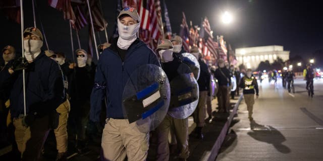 Members of the right-wing group Patriot Front march across Memorial Bridge in front of the Lincoln Memorial on December 04, 2021