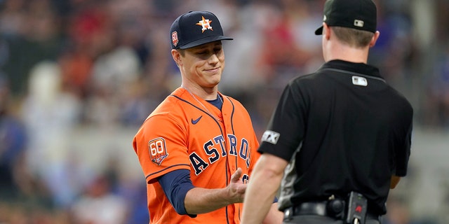 Houston Astros relief pitcher Phil Maton, left, has his hand checked for foreign substances while heading to the dugout during the seventh inning of a baseball game against the Texas Rangers in Arlington, Texas, Wednesday, June 15, 2022. The Astros won 9- 2. 