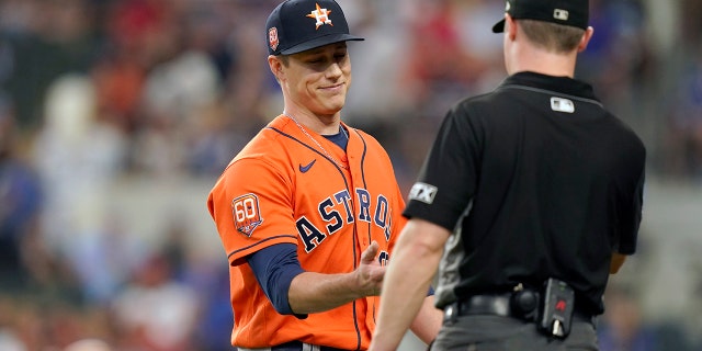 Houston Astros relief pitcher Phil Maton, left, has his hand checked for foreign substances while heading to the dugout during the seventh inning of a baseball game against the Texas Rangers in Arlington, Texas, Wednesday, June 15, 2022. The Astros won 9-2. 