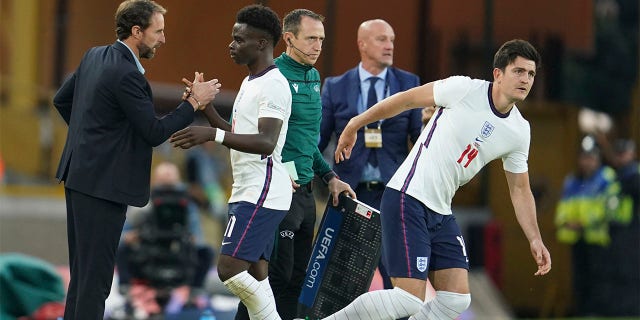 England's coach Gareth Southgate, left, shakes hands with England's Bukayo Saka as he is substituted during the UEFA Nations League soccer match between England and Hungary at the Molineux stadium in Wolverhampton, England, Tuesday, June 14, 2022.