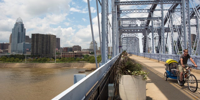 A cyclist traverses the Purple People bridge in Cincinnati, Ohio July 2, 2013. 