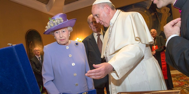 FILE - Her Majesty Queen Elizabeth II exchanges gifts with His Holiness, Pope Francis, during an audience in the Pope's study inside the Paul VI Hall on her one-day visit to Rome on April 3, 2014 in Vatican City, Vatican.