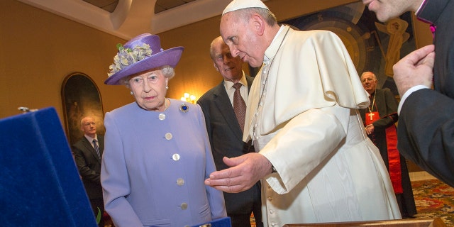 FILE - Her Majesty Queen Elizabeth II exchanges gifts with His Holiness, Pope Francis, during an audience in the Pope's study inside the Paul VI Hall on her one-day visit to Rome on April 3, 2014 in Vatican City, Vatican.