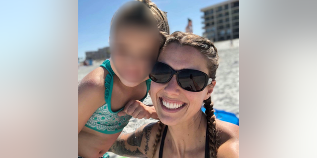 Shanna Gardner-Fernandez with her daughter on the beach.