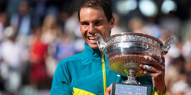 Spain's Rafael Nadal bites the trophy after winning the final match against Norway's Casper Ruud in three sets, 6-3, 6-3, 6-0, at the French Open tennis tournament in Roland Garros stadium in Paris, France, Sunday, June 5, 2022.