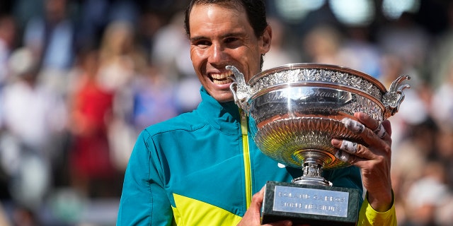 Spain's Rafael Nadal bites the trophy after winning the final match against Norway's Casper Ruud in three sets, 6-3, 6-3, 6-0, at the French Open at Roland Garros stadium in Paris Sunday, June 5, 2022.