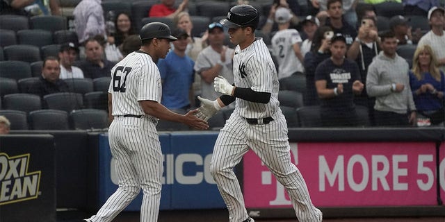 New York Yankees' Anthony Rizzo, is congratulated by third base coach Luis Rojas as he runs the bases after his home run during the first inning of a baseball game against the Oakland Athletics, Monday, June 27, 2022, in New York. 