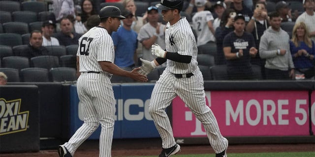 New York Yankees' Anthony Rizzo, is congratulated by third base coach Luis Rojas as he runs the bases after his home run during the first inning of a baseball game against the Oakland Athletics, Monday, June 27, 2022, in New York. 