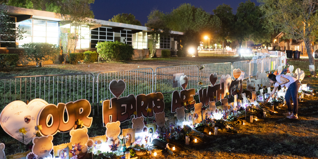 A woman visits at a memorial at Robb Elementary School in Uvalde, Texas, on Wednesday, June 1, to pay her respects to the victims killed in last week's school shooting.