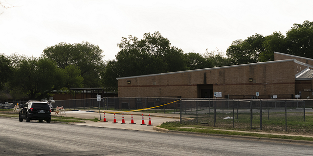 A police vehicle is parked near a back door at Robb Elementary School Wednesday, June 1, 2022, in Uvalde, Texas, where a gunman entered to get into a classroom last week.