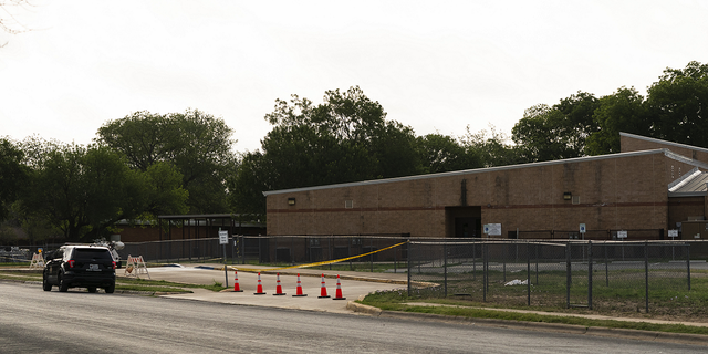 A police vehicle is parked near a back door at Robb Elementary School Wednesday, June 1, 2022, in Uvalde, Texas, where a gunman entered to get into a classroom last week.