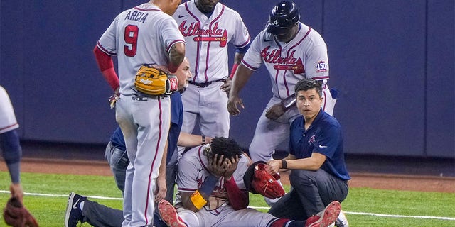 Ronald Acuna Jr. #13 of the Atlanta Braves sits with his head in this hands after an injury during the fifth inning against the Miami Marlins during the fifth inning against the Miami Marlins  at loanDepot park on July 10, 2021 in Miami, Florida. 