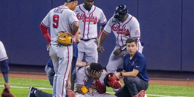 Ronald Acuna Jr. #13 of the Atlanta Braves sits with his head in this hands after an injury during the fifth inning against the Miami Marlins during the fifth inning against the Miami Marlins  at loanDepot park on July 10, 2021 in Miami, Florida. 