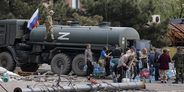 Local civilians gather to receive pure water distributed by Russian Emergency Situations Ministry in Mariupol, in territory under the government of the Donetsk People's Republic, eastern Ukraine, on Friday, May 27.