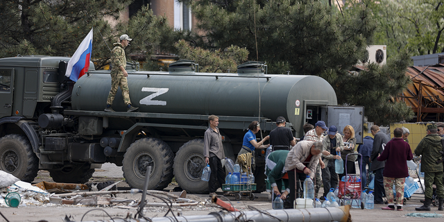 Local civilians gather to receive pure water distributed by Russian Emergency Situations Ministry in Mariupol, in territory under the government of the Donetsk People's Republic, eastern Ukraine, on Friday, May 27.