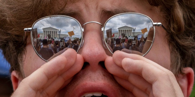 An abortion-rights protester shouts slogans following Supreme Court's decision to overturn Roe v. Wade, federally protected right to abortion, in Washington, Friday, June 24, 2022. The Supreme Court has ended constitutional protections for abortion that had been in place nearly 50 years, a decision by its conservative majority to overturn the court's landmark abortion cases. 