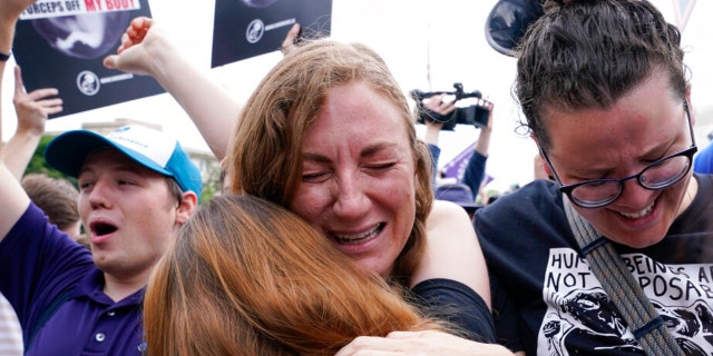 People celebrate following Supreme Court's decision to overturn Roe v. Wade in Washington, Friday, June 24, 2022. The Supreme Court has ended constitutional protections for abortion that had been in place nearly 50 years, a decision by its conservative majority to overturn the court's landmark abortion cases.