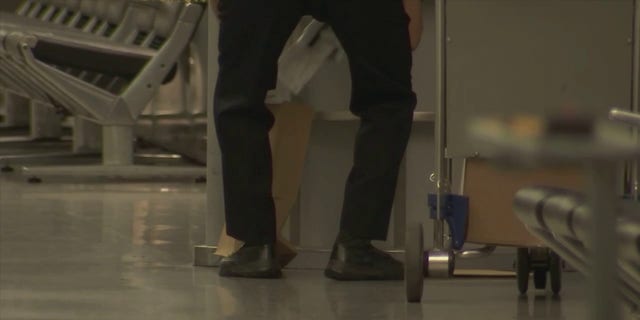 Police at San Francisco International Airport were seen after a man injured three people in an attack with an "edged weapon" Friday, June 17, 2022, officials said. One officer put papers and other items on the ground into a brown paper bag.
