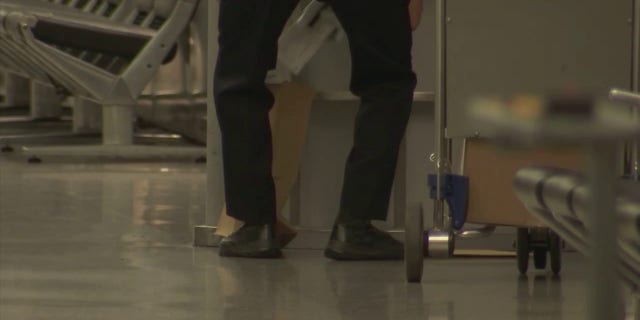 Police at San Francisco International Airport were seen after a man injured three people in an attack with an "edged weapon" Friday, June 17, 2022, officials said. One officer put papers and other items on the ground into a brown paper bag.