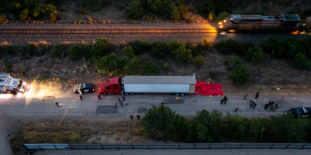 In this aerial photograph, law enforcement members are investigating a tractor trailer in San Antonio, Texas, on June 27, 2022. At least 46 suspected migrant workers from Mexico were reportedly found dead in abandoned tractor trailers. More than 12 victims who suffered from heat stroke and were taken to a local hospital were found alive. (Photo courtesy of 