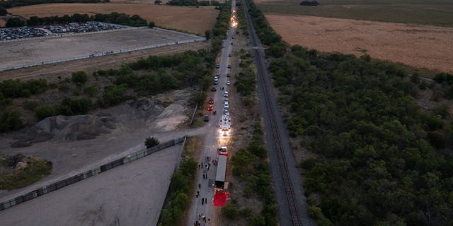 In this aerial photograph, law enforcement members are investigating a tractor trailer in San Antonio, Texas, on June 27, 2022. At least 46 suspected migrant workers from Mexico were reportedly found dead in abandoned tractor trailers. More than 12 victims who suffered from heat stroke and were taken to a local hospital were found alive. (Photo courtesy of 