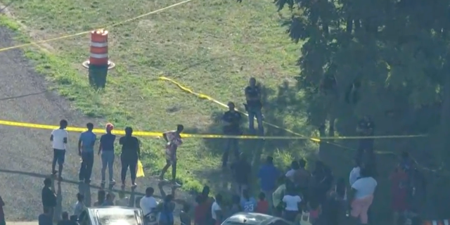 A large crowd gathered outside the scene on Wednesday after the bodies were discovered. 