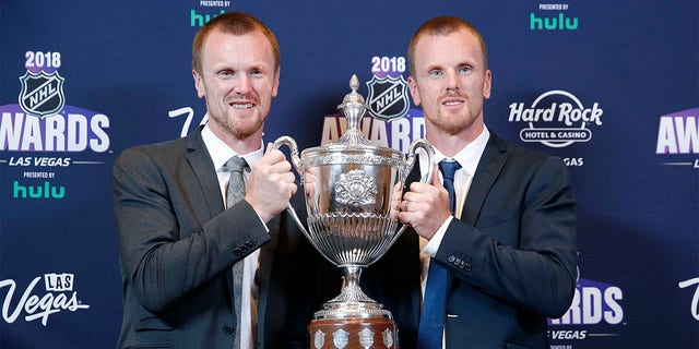 Daniel Sedin, right, and Henrik Sedin pose with the King Clancy Memorial Trophy after winning the award at the NHL Awards, Wednesday, June 20, 2018, in Las Vegas. Swedes Henrik and Daniel Sedin and Daniel Alfredsson have been elected to the Hockey Hall of Fame. Goaltender Roberto Luongo, Finnish women’s star Riikka Sallinen and builder Herb Carnegie were also selected Monday, June 27, 2022, to be inducted in November. 