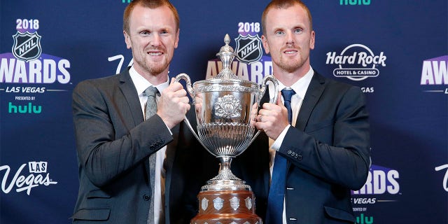 Daniel Sedin, right, and Henrik Sedin pose with the King Clancy Memorial Trophy after winning the award at the NHL Awards, Wednesday, June 20, 2018, in Las Vegas. Swedes Henrik and Daniel Sedin and Daniel Alfredsson have been elected to the Hockey Hall of Fame. Goaltender Roberto Luongo, Finnish women’s star Riikka Sallinen and builder Herb Carnegie were also selected Monday, June 27, 2022, to be inducted in November. 