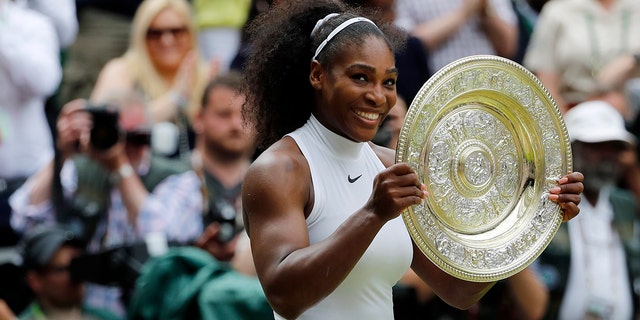 Serena Williams holds her trophy after winning the women's singles final against Angelique Kerber at the Wimbledon Tennis Championships in London, July 9, 2016.
