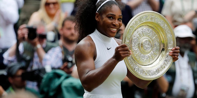 Serena Williams holds her trophy after winning the women's singles final against Angelique Kerber at the Wimbledon Tennis Championships in London, July 9, 2016.