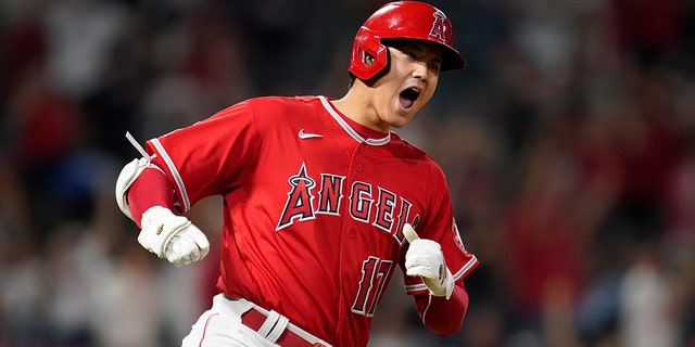Los Angeles Angels designated hitter Shohei Ohtani (17) reacts after hitting a home run during the ninth inning of a baseball game against the Kansas City Royals on Tuesday, June 21, 2022 in Anaheim, Calif.  Mike Trout and Tyler Wade also scored.