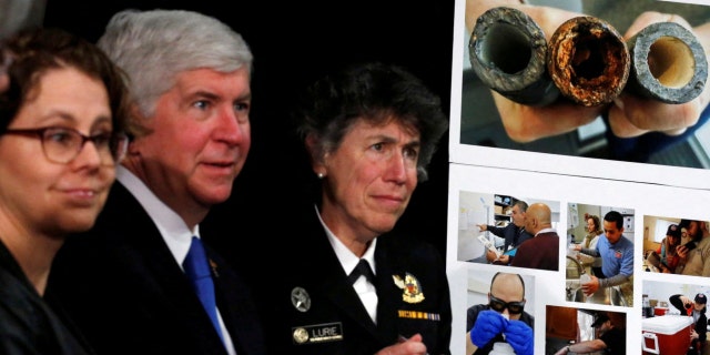 Pictures of damaged pipes from Flint, a city that struggled with the effects of lead-poisoned drinking water, is seen as then-Michigan Gov. Rick Snyder (2nd L) attended a meeting between local and federal authorities with former President Obama in Michigan, May 4, 2016.