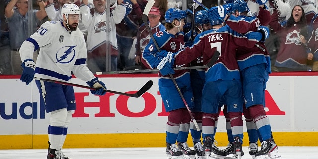 Colorado Avalanche players celebrate a goal by Valeri Nichushkin as Tampa Bay Lightning left wing Nicholas Paul, left, skates past during the first period in Game 2 of the NHL hockey Stanley Cup Final on Saturday, June 18, 2022, in Denver. (AP Photo/John Locher)