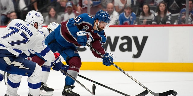 Colorado Avalanche center Darren Helm (43) shoots for a goal during the second period against the Tampa Bay Lightning in Game 2 of the NHL hockey Stanley Cup Final, Saturday, June 18, 2022, in Denver. (AP Photo/John Locher)