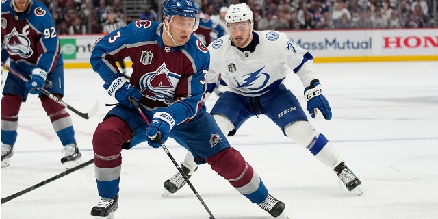 Colorado Avalanche defenseman Jack Johnson (3) controls the puck as Tampa Bay Lightning center Ross Colton (79) defends during the third period in Game 2 of the NHL hockey Stanley Cup Final, Saturday, June 18, 2022, in Denver. (AP Photo/John Locher)