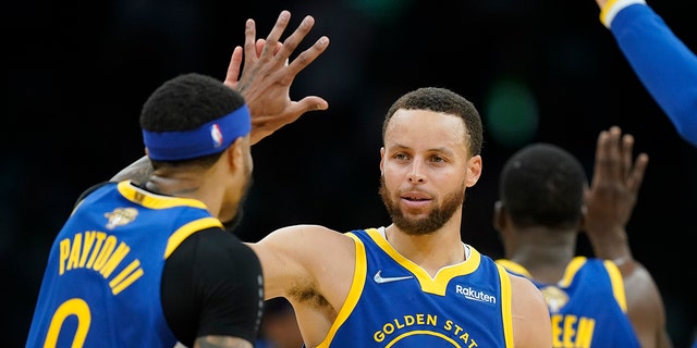 Golden State Warriors guard Stephen Curry (30) high fives Golden State Warriors guard Gary Payton II (0) during the second quarter of Game 6 of basketball's NBA Finals against the Boston Celtics, Thursday, June 16, 2022, in Boston.