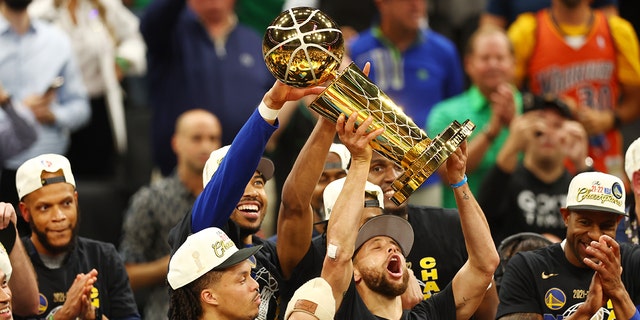 Stephen Curry raises the Larry O'Brien Championship Trophy after the Golden State Warriors defeated the Boston Celtics, 103-90, in Game Six of the NBA Finals on June 16, 2022.